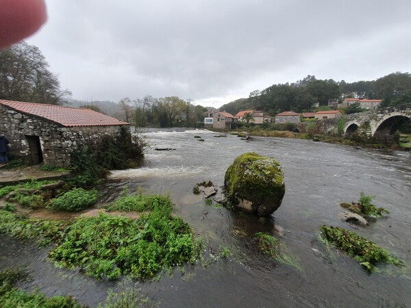 Ponto Maceira at river Tambre. Powerful water flow. Mill house to the left