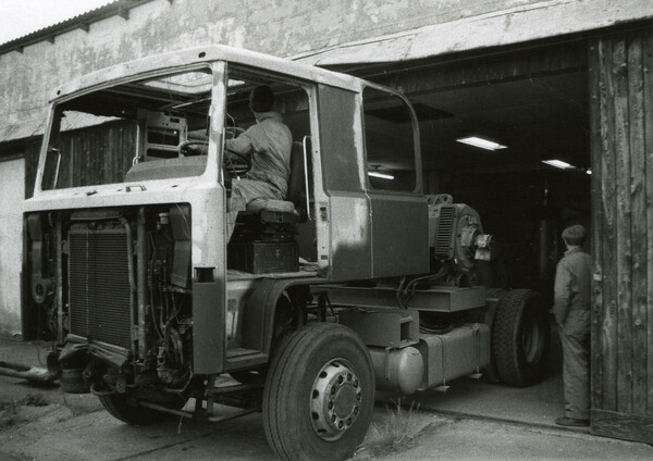 Vagn Toft kører lastbilen til det dieselelektriske spil køres ind i Hallings værksted. Allan Rasmussen til højre.